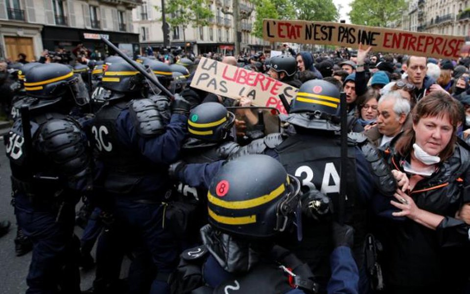 French riot police surround demonstrators who hold a placard with the message, 'The State is not an Company', the day after the country went to the polls, in Paris, France, May 8, 2017. REUTERS/Jean-Paul Pelissier (Foto: Paulo Emílio) French riot police surround demonstrators who hold a placard with the message, 'The State is not an Company', the day after the country went to the polls, in Paris, France, May 8, 2017. REUTERS/Jean-Paul Pelissier