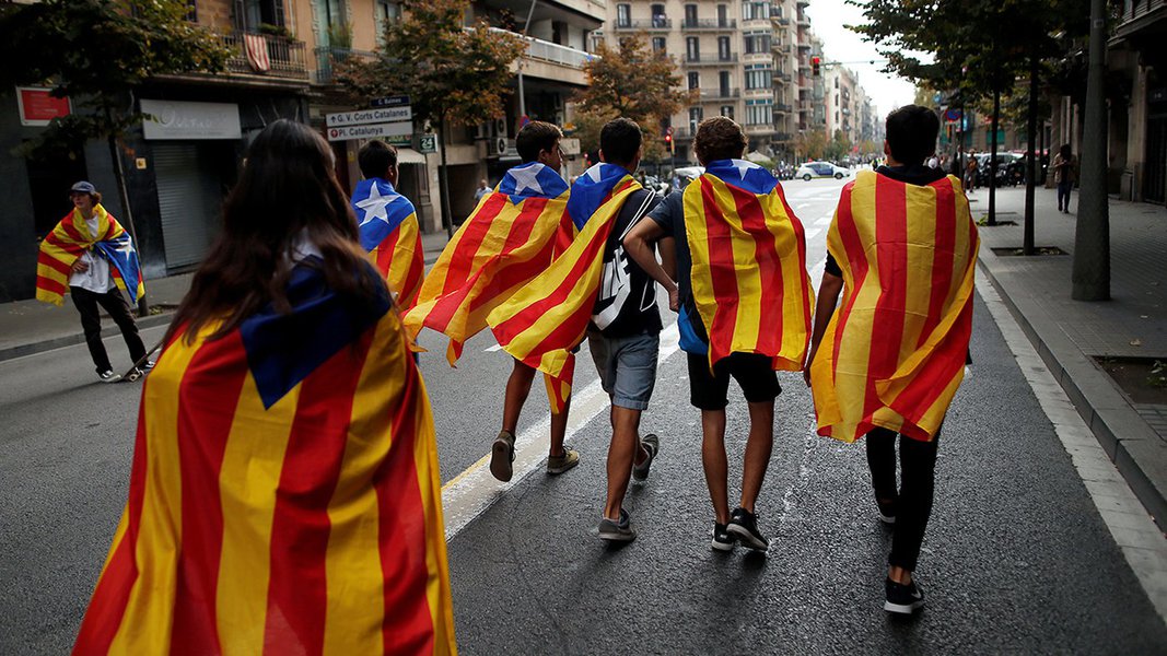 Jovens enrolados em bandeiras separatistas da Catalunha caminham durante protesto em Barcelona 03/10/2017 REUTERS/Jon Nazca (Foto: Aquiles Lins) Jovens enrolados em bandeiras separatistas da Catalunha caminham durante protesto em Barcelona 03/10/2017 REUTERS/Jon Nazca