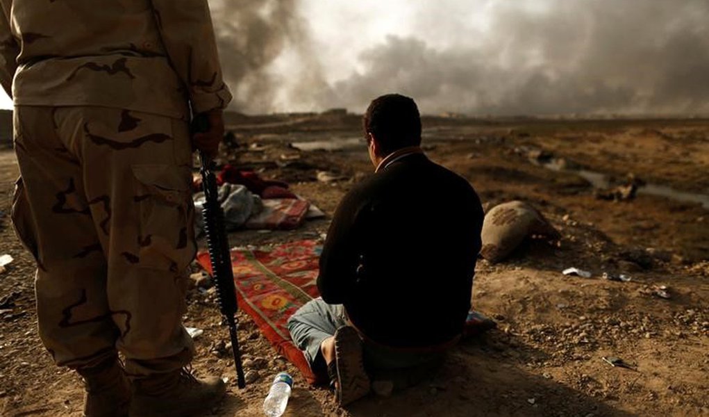 An Iraqi soldier stands next to a detained man accused of being an Islamic State fighter at a check point in Qayyara, south of Mosul, Iraq October 30, 2016. REUTERS/Zohra Bensemra (Foto: Paulo Emílio) An Iraqi soldier stands next to a detained man accused of being an Islamic State fighter at a check point in Qayyara, south of Mosul, Iraq October 30, 2016. REUTERS/Zohra Bensemra