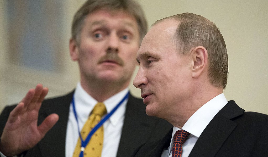 In this photo taken on Thursday, Feb. 12, 2015, Russian President Vladimir Putin, right, speaks to a journalist as his press secretory Dmitry Peskov tries to stop questions after the peace talks in Minsk, Belarus, Thursday, Feb. 12, 2015. Peskov told (Foto: Paulo Emílio) In this photo taken on Thursday, Feb. 12, 2015, Russian President Vladimir Putin, right, speaks to a journalist as his press secretory Dmitry Peskov tries to stop questions after the peace talks in Minsk, Belarus, Thursday, Feb. 12, 2015. Peskov told