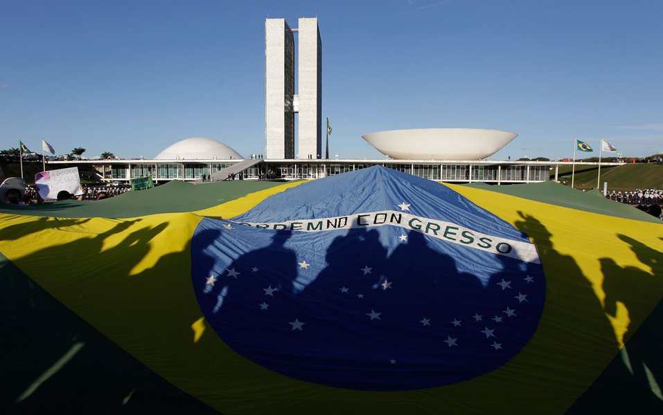 Demonstrators open a Brazil's flag in front of the National Congress during a protest in Brasilia, Brazil, Wednesday, June 26, 2013. The wave of protests that hit Brazil on June 17 began as opposition to transportation fare hikes, then expanded to a list (Foto: Daniel Quoist) Demonstrators open a Brazil's flag in front of the National Congress during a protest in Brasilia, Brazil, Wednesday, June 26, 2013. The wave of protests that hit Brazil on June 17 began as opposition to transportation fare hikes, then expanded to a list