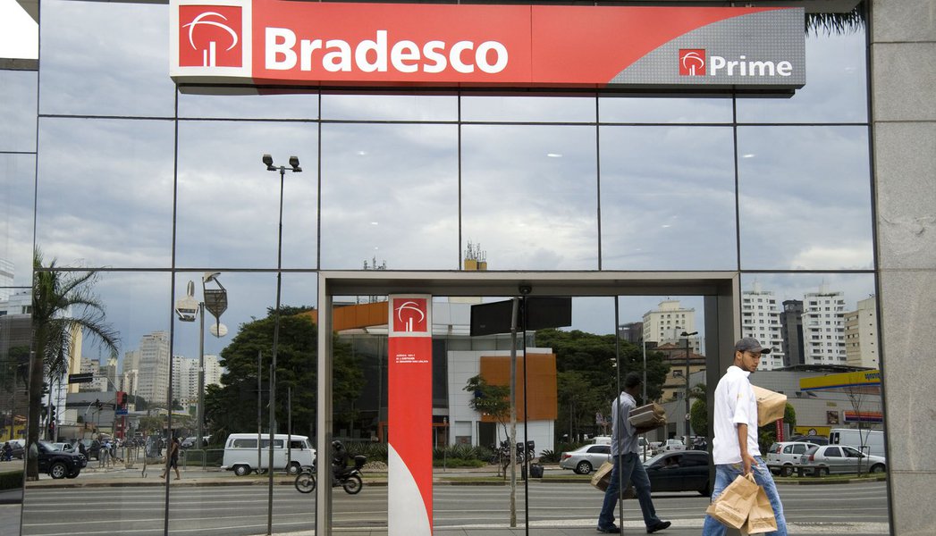 A man walks past a Banco Bradesco SA branch Sao Paulo, Brazil, on Monday, Aug. 3, 2009. Bradesco, Brazil's second-largest non-government bank, said quarterly profit climbed 15 percent, helped by gains from the sale of its stake in a credit-card company an (Foto: Aquiles Lins) A man walks past a Banco Bradesco SA branch Sao Paulo, Brazil, on Monday, Aug. 3, 2009. Bradesco, Brazil's second-largest non-government bank, said quarterly profit climbed 15 percent, helped by gains from the sale of its stake in a credit-card company an