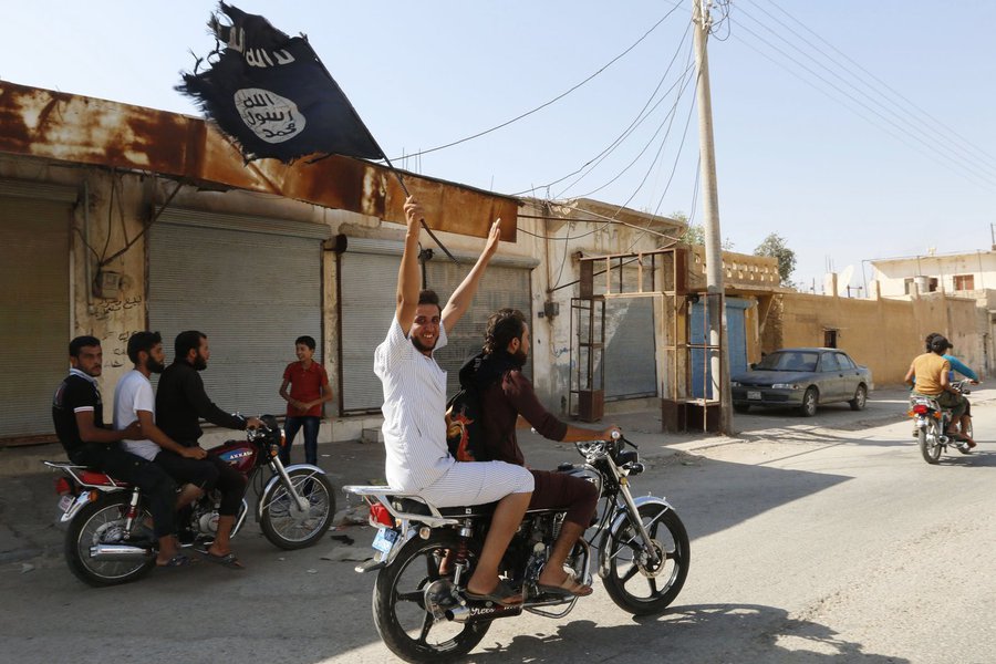 Moradores de Tabqa erguem bandeira do Estado Islâmico perto de Raqqa. 24/08/2014 REUTERS/Stringer (Foto: Gisele Federicce) Moradores de Tabqa erguem bandeira do Estado Islâmico perto de Raqqa. 24/08/2014 REUTERS/Stringer