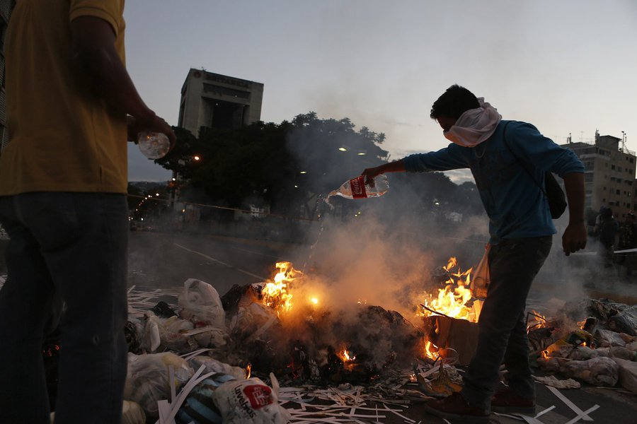Opposition supporters stand near a burning barricade at Altamira square in Caracas February 20, 2014. Venezuelan security forces and demonstrators faced off in streets blocked by burning barricades in several provincial cities on Thursday as protests esca (Foto: Gisele Federicce) Opposition supporters stand near a burning barricade at Altamira square in Caracas February 20, 2014. Venezuelan security forces and demonstrators faced off in streets blocked by burning barricades in several provincial cities on Thursday as protests esca