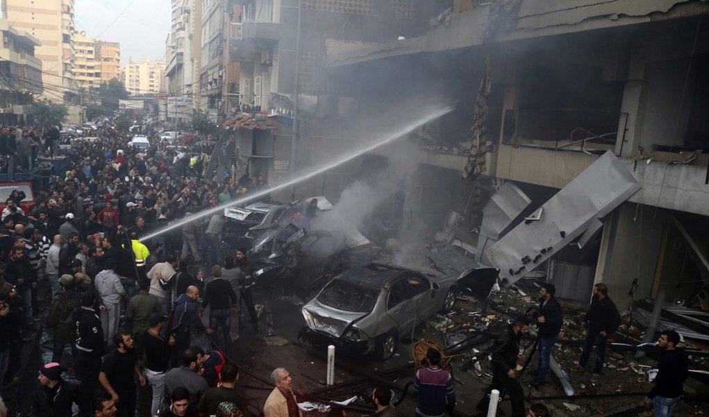 People gather as firefighters attempt to extinguish a fire at the site of an explosion in Beirut's southern suburbs, January 2, 2014. A car bomb killed four people in Hezbollah's southern Beirut stronghold on Thursday, security and medical sources said, t (Foto: Leonardo Attuch) People gather as firefighters attempt to extinguish a fire at the site of an explosion in Beirut's southern suburbs, January 2, 2014. A car bomb killed four people in Hezbollah's southern Beirut stronghold on Thursday, security and medical sources said, t