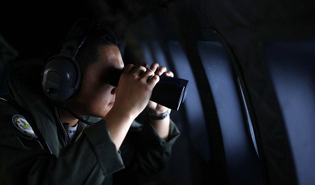 A crew member from the Royal Malaysian Air Force uses binoculars onboard a Malaysian Air Force CN235 aircraft during a Search and Rescue (SAR) operation to find the missing Malaysia Airlines flight MH370, in the Straits of Malacca March 13, 2014. REUTERS/ (Foto: Gisele Federicce) A crew member from the Royal Malaysian Air Force uses binoculars onboard a Malaysian Air Force CN235 aircraft during a Search and Rescue (SAR) operation to find the missing Malaysia Airlines flight MH370, in the Straits of Malacca March 13, 2014. REUTERS/