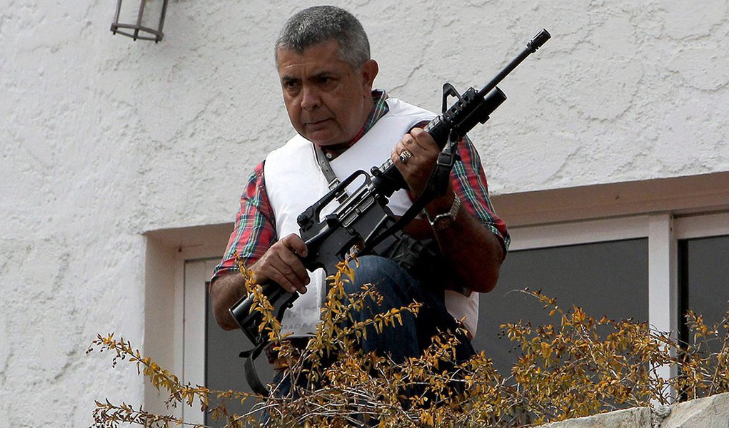 Angel Vivas, a retired army general and anti-Maduro protester, stands in his house with an automatic weapon as he resists be detained in Caracas February 23, 2014. According to local media, President Nicolas Maduro ordered the detention of Vivas on Saturd (Foto: Roberta Namour) Angel Vivas, a retired army general and anti-Maduro protester, stands in his house with an automatic weapon as he resists be detained in Caracas February 23, 2014. According to local media, President Nicolas Maduro ordered the detention of Vivas on Saturd
