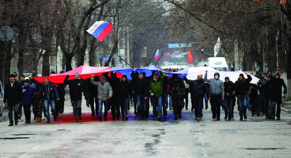 Pro-Russian demonstrators march with a huge Russian flag during a protest in front of a local government building in Simferopol, Crimea, Ukraine, Thursday, Feb. 27, 2014. Ukraine's acting interior minister says Interior Ministry troops and police have bee (Foto: Leonardo Attuch) Pro-Russian demonstrators march with a huge Russian flag during a protest in front of a local government building in Simferopol, Crimea, Ukraine, Thursday, Feb. 27, 2014. Ukraine's acting interior minister says Interior Ministry troops and police have bee