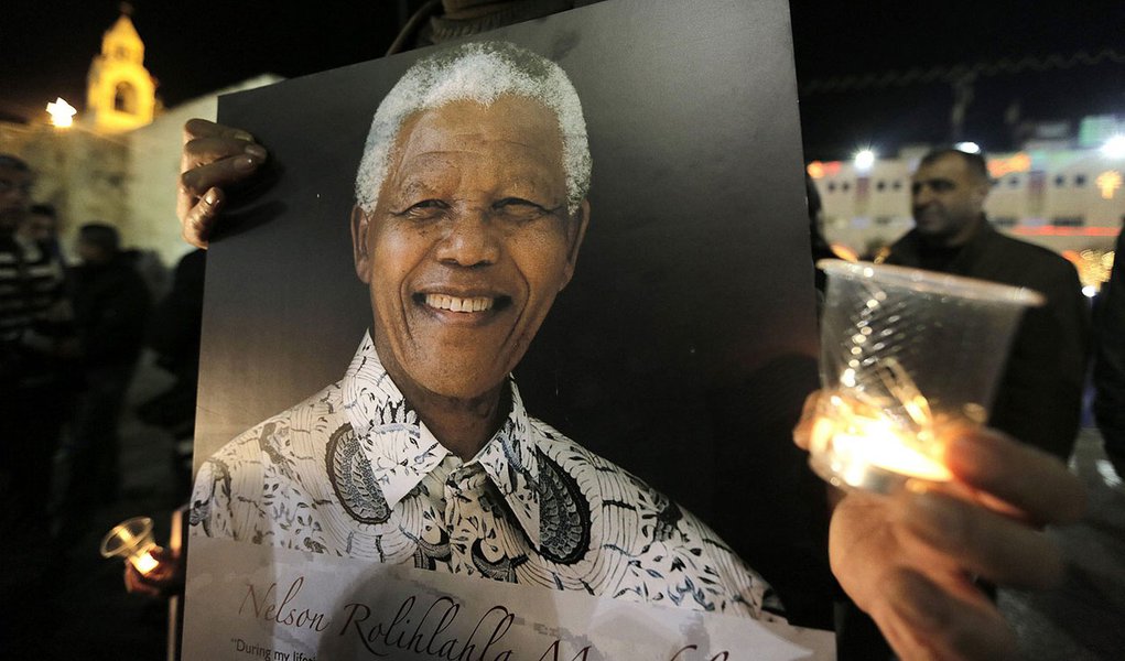 Palestinians light candles and hold placards bearing images of former South African President Nelson Mandela outside the Church of Nativity in the West Bank town of Bethlehem December 7, 2013. South African anti-apartheid hero Mandela died peacefully at h (Foto: Gisele Federicce) www.brasil247.com - Palestinians light candles and hold placards bearing images of former South African President Nelson Mandela outside the Church of Nativity in the West Bank town of Bethlehem December 7, 2013. South African anti-apartheid hero Mandela died peacefully at h
