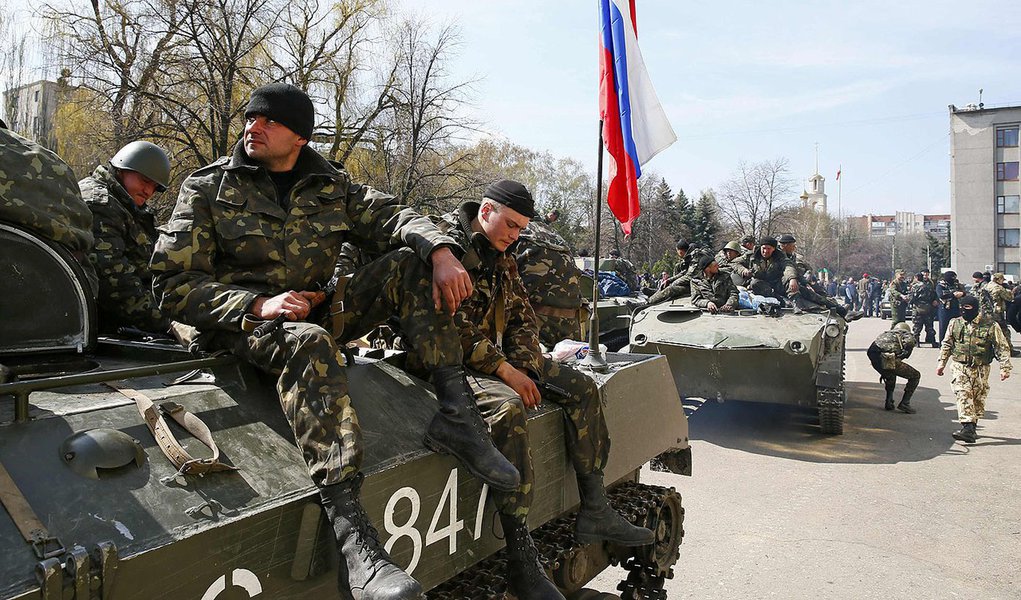 Armed men sit on an armoured personnel carrier with a Russian flag on it in Slaviansk April 16, 2014. Six armoured troop carriers entered the eastern Ukrainian town of Slaviansk on Wednesday carrying the Russian national flag and the banner of pro-Russian (Foto: Paulo Emílio) Armed men sit on an armoured personnel carrier with a Russian flag on it in Slaviansk April 16, 2014. Six armoured troop carriers entered the eastern Ukrainian town of Slaviansk on Wednesday carrying the Russian national flag and the banner of pro-Russian