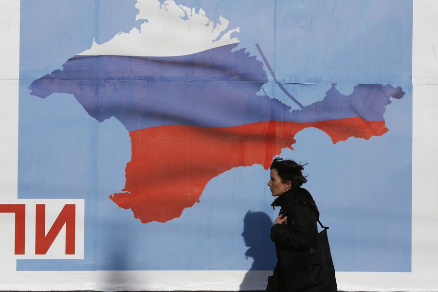 A woman walks by a poster in the Crimean port city of Sevastopol March 10, 2014. Crimea's parliament, dominated by ethnic Russians, voted to join Russia last week and set a referendum for March 16, escalating the crisis. REUTERS/Baz Ratner (UKRAINE - Tags (Foto: Gisele Federicce) A woman walks by a poster in the Crimean port city of Sevastopol March 10, 2014. Crimea's parliament, dominated by ethnic Russians, voted to join Russia last week and set a referendum for March 16, escalating the crisis. REUTERS/Baz Ratner (UKRAINE - Tags