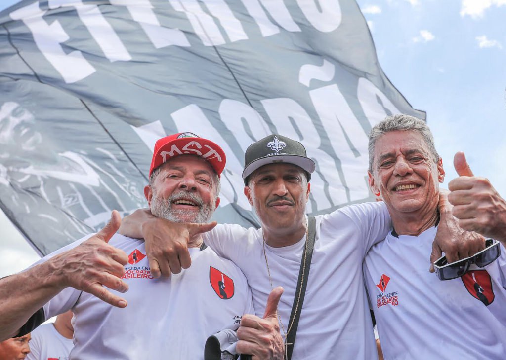 Mano Brown trouxe seu abraço de fim de ano e o desejo de um feliz 2018 para Lula e Chico Buarque na partida de futebol de inauguração do campo Doutor Sócrates Brasileiro na Escola Nacional Florestan Fernandes, do MST. Foto: Ricardo Stuckert (Foto: Gustavo Conde) Mano Brown trouxe seu abraço de fim de ano e o desejo de um feliz 2018 para Lula e Chico Buarque na partida de futebol de inauguração do campo Doutor Sócrates Brasileiro na Escola Nacional Florestan Fernandes, do MST. Foto: Ricardo Stuckert