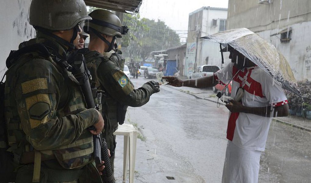 Militares estão fotografando todo mundo que sai das favelas Vila Kennedy, Coréia e Vila Aliança, na Zona Oeste, durante operação nesta sexta-feira (23); diferentes pontos de identificação foram montados em diversas saídas das comunidades; as pessoas só podem deixar suas regiões após passarem pelo cadastramento das Forças Armadas; foto e o RG dos moradores são enviados por um aplicativo para um setor de inteligência das forças de segurança, que avalia se o identificado tem anotação criminal (Foto: Aquiles Lins) Militares estão fotografando todo mundo que sai das favelas Vila Kennedy, Coréia e Vila Aliança, na Zona Oeste, durante operação nesta sexta-feira (23); diferentes pontos de identificação foram montados em diversas saídas das comunidades; as pessoas só podem deixar suas regiões após passarem pelo cadastramento das Forças Armadas; foto e o RG dos moradores são enviados por um aplicativo para um setor de inteligência das forças de segurança, que avalia se o identificado tem anotação criminal
