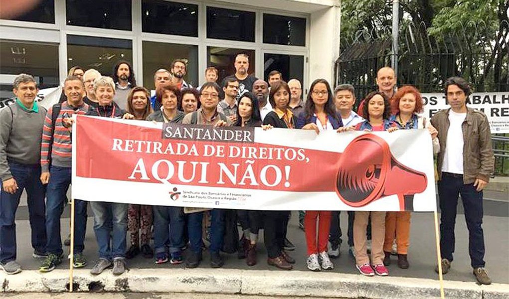 Bancários de todo o país protestam em locais de trabalho do Santander, após o banco espanhol ter implementado pontos da "reforma" trabalhista que violam termos negociados no acordo coletivo, válido até 31 de agosto; unidade brasileira do Santander responde por 26% do lucro mundial da rede espanhola – a maior taxa de participação do mundo; para a coordenadora da Comissão de Organização dos Empregados (COE) do Santander, Maria Rosani, o banco tenta fazer prevalecer o "legislado com a reforma trabalhista sobre o negociado" com os trabalhadores (Foto: Paulo Emílio) Bancários de todo o país protestam em locais de trabalho do Santander, após o banco espanhol ter implementado pontos da "reforma" trabalhista que violam termos negociados no acordo coletivo, válido até 31 de agosto; unidade brasileira do Santander responde por 26% do lucro mundial da rede espanhola – a maior taxa de participação do mundo; para a coordenadora da Comissão de Organização dos Empregados (COE) do Santander, Maria Rosani, o banco tenta fazer prevalecer o "legislado com a reforma trabalhista sobre o negociado" com os trabalhadores