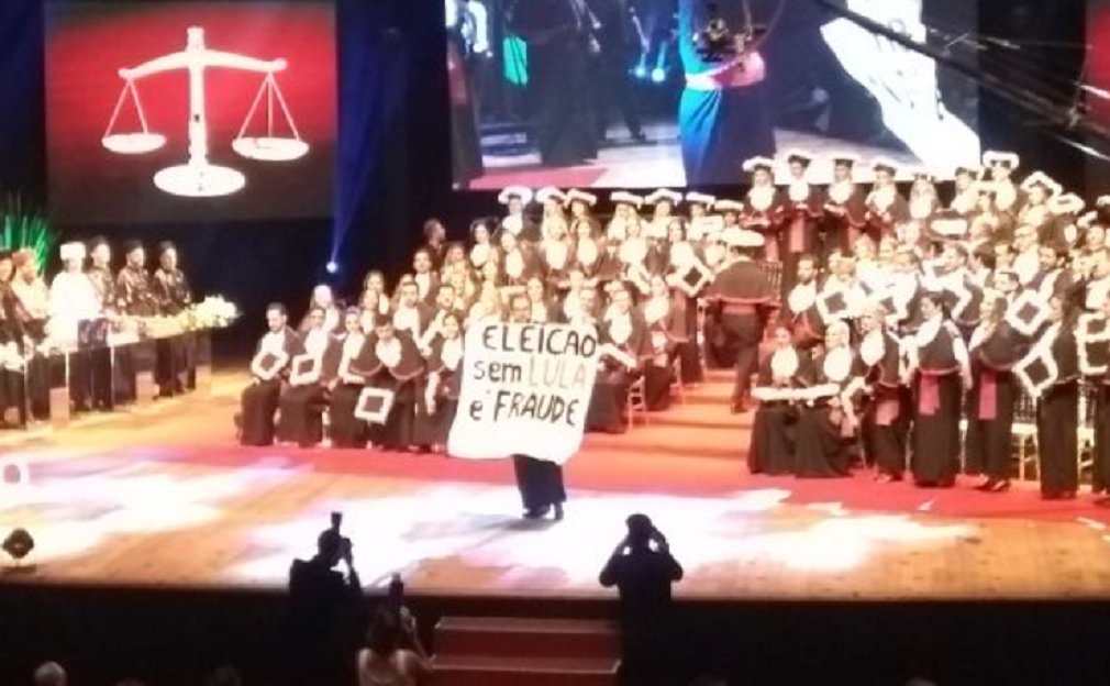 As manifestações de apoio ao ex-presidente Lula não param de aparecer. Na sexta-feira (19), em cerimônia de formatura do curso de Direito da Unisinos-RS, um formando estendeu faixa com os dizeres: “Eleições sem Lula é fraude”; Lula será julgado em segunda instância pelo TRF4, em Porto Alegre; caravanas de todo o país já estão a caminho da capital gaúcha (Foto: José Barbacena) As manifestações de apoio ao ex-presidente Lula não param de aparecer. Na sexta-feira (19), em cerimônia de formatura do curso de Direito da Unisinos-RS, um formando estendeu faixa com os dizeres: “Eleições sem Lula é fraude”; Lula será julgado em segunda instância pelo TRF4, em Porto Alegre; caravanas de todo o país já estão a caminho da capital gaúcha