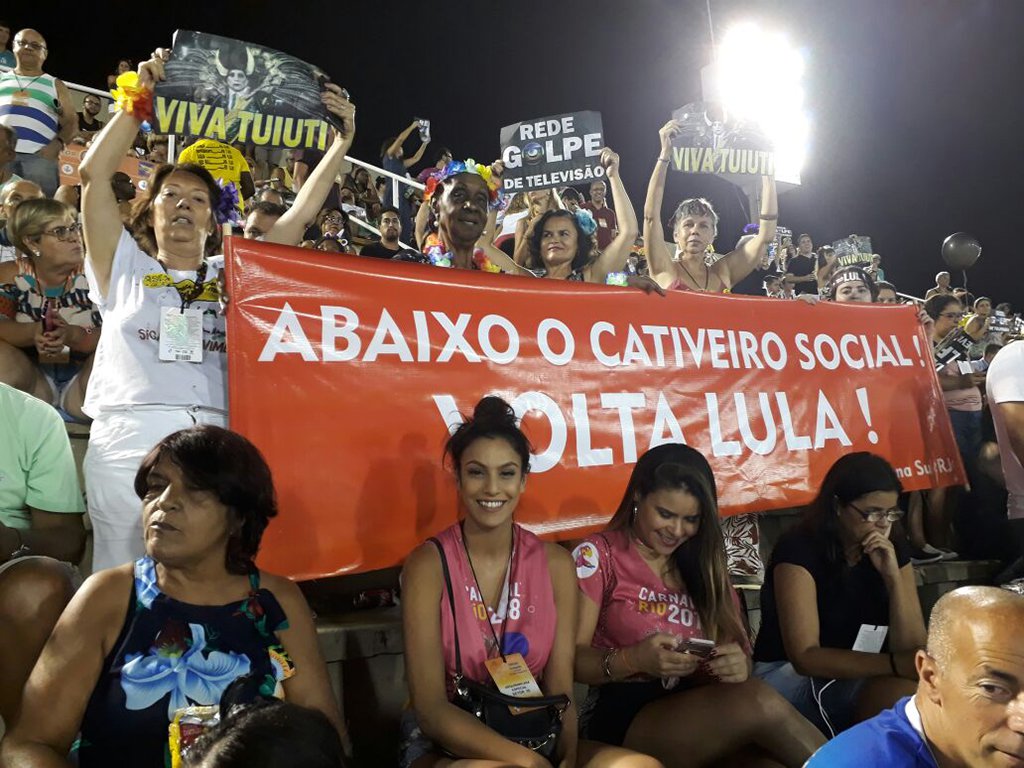 Algumas pessoas presentes na reapresentação do desfile seguravam uma faixa que dizia: "Abaixo o cativeiro social. Volta Lula!"; apesar de ser vítima de intensa caçada judicial e condenado sem provas, o petista segue líder absoluto em todas as pesquisas e já foi apontado como o melhor presidente da história, segundo levantamentos oficiais; enquanto isso, Michel Temer é rejeitado por mais de 90% dos brasileiros e coloca em prática uma dura política que implica em retrocessos sociais (Foto: Leonardo Lucena) Algumas pessoas presentes na reapresentação do desfile seguravam uma faixa que dizia: "Abaixo o cativeiro social. Volta Lula!"; apesar de ser vítima de intensa caçada judicial e condenado sem provas, o petista segue líder absoluto em todas as pesquisas e já foi apontado como o melhor presidente da história, segundo levantamentos oficiais; enquanto isso, Michel Temer é rejeitado por mais de 90% dos brasileiros e coloca em prática uma dura política que implica em retrocessos sociais
