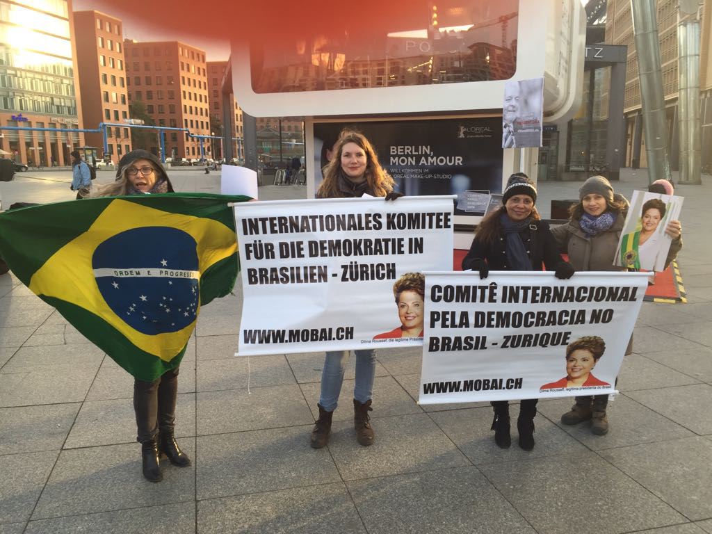 Um grupo de cerca de trinta manifestantes brasileiros se encontra em frente ao Potsdammerplatz, em Berlim, protestando pela democracia e contra os abusos do judiciário cometidos contra o ex-presidente Lula; nesta quarta-feira (21), acontece a estreia mundial do documentário O Processo, dirigido por Maria Augusta Ramos, que mostra os bastidores do golpe de 2016 (Foto: Aquiles Lins) Um grupo de cerca de trinta manifestantes brasileiros se encontra em frente ao Potsdammerplatz, em Berlim, protestando pela democracia e contra os abusos do judiciário cometidos contra o ex-presidente Lula; nesta quarta-feira (21), acontece a estreia mundial do documentário O Processo, dirigido por Maria Augusta Ramos, que mostra os bastidores do golpe de 2016