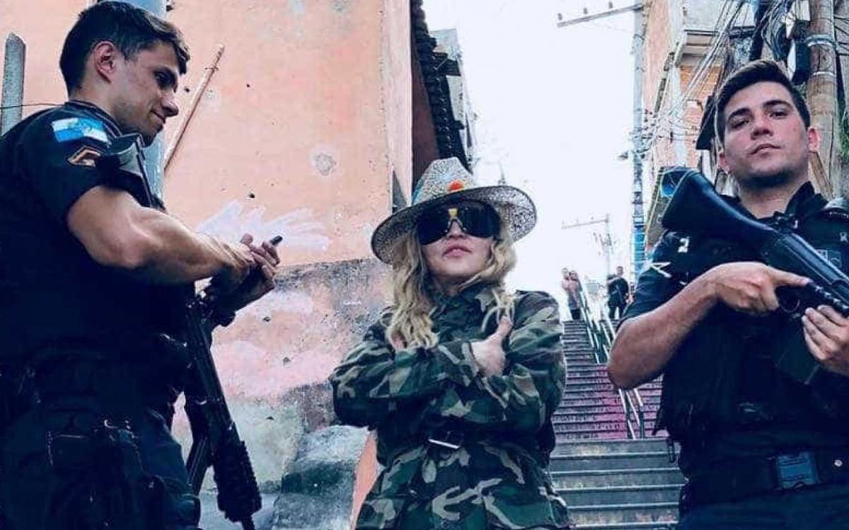 O policial Raiff Medeiros negou que a Polícia Militar do Rio de Janeiro tenha escoltado a cantora Madonna em visita ao Morro da Providência, conforme acusou o Movimento Brasil Livre (MBL) em postagem nas redes sociais; "Foi de surpresa", disse Raiff, que posou para foto com a artista norte americana; após a visita à comunidade na quarta-feira (25) Madonna publicou nas redes sociais uma foto ao lado de policiais armados com fuzis (Foto: Romulo Faro) O policial Raiff Medeiros negou que a Polícia Militar do Rio de Janeiro tenha escoltado a cantora Madonna em visita ao Morro da Providência, conforme acusou o Movimento Brasil Livre (MBL) em postagem nas redes sociais; "Foi de surpresa", disse Raiff, que posou para foto com a artista norte americana; após a visita à comunidade na quarta-feira (25) Madonna publicou nas redes sociais uma foto ao lado de policiais armados com fuzis