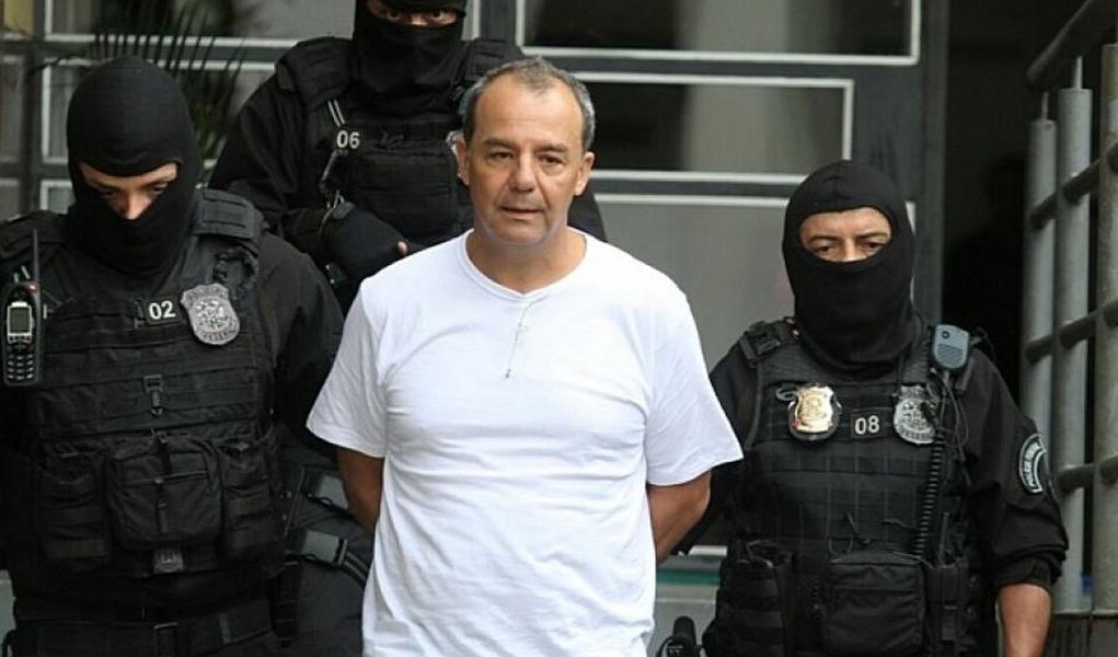 Nesta sexta-feira (17), dia em que Sérgio Cabral completa um ano preso, um grupo de manifestantes fez um protesto contra o ex-governador em frente à Cadeia Pública José Frederico Marques, em Benfica, na Zona Norte do Rio; com cartazes, tambores e até espumantes, os manifestantes também cobravam a permanência do presidente da Assembleia Legislativa (Alerj), Jorge Picciani, e dos deputados Paulo Melo e Edson Albertassi, todos do PMDB, na prisão; Cabral foi preso no dia 17 de novembro de 2016, na Operação Calicute, acusado de receber propina para fechar contratos públicos; o ex-governador é réu em 16 processos, e já tem três condenações (Foto: Leonardo Lucena) Nesta sexta-feira (17), dia em que Sérgio Cabral completa um ano preso, um grupo de manifestantes fez um protesto contra o ex-governador em frente à Cadeia Pública José Frederico Marques, em Benfica, na Zona Norte do Rio; com cartazes, tambores e até espumantes, os manifestantes também cobravam a permanência do presidente da Assembleia Legislativa (Alerj), Jorge Picciani, e dos deputados Paulo Melo e Edson Albertassi, todos do PMDB, na prisão; Cabral foi preso no dia 17 de novembro de 2016, na Operação Calicute, acusado de receber propina para fechar contratos públicos; o ex-governador é réu em 16 processos, e já tem três condenações