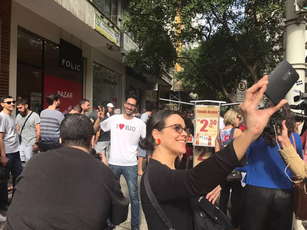 Chamado de 'esfihaço', um ato solidário reuniu centenas de cariocas em apoio ao refugiado sírio Mohammed Ali, vítima de xenofobia recentemente no Rio de Janeiro; o imigrante, que vende salgados árabes numa calçada em Copacabana, foi agredido verbalmente por um vendedor ambulante, que exigia que ele saísse do Brasil; a fila para comprar esfihas e quibes era formada por um número de 20 a 30 pessoas; Mohamed ficou o tempo todo ocupado, ora atendendo os pedidos, ora no caixa; ele só parava por poucos segundos para atender a pedidos de fotos dos clientes (Foto: Romulo Faro) Chamado de 'esfihaço', um ato solidário reuniu centenas de cariocas em apoio ao refugiado sírio Mohammed Ali, vítima de xenofobia recentemente no Rio de Janeiro; o imigrante, que vende salgados árabes numa calçada em Copacabana, foi agredido verbalmente por um vendedor ambulante, que exigia que ele saísse do Brasil; a fila para comprar esfihas e quibes era formada por um número de 20 a 30 pessoas; Mohamed ficou o tempo todo ocupado, ora atendendo os pedidos, ora no caixa; ele só parava por poucos segundos para atender a pedidos de fotos dos clientes