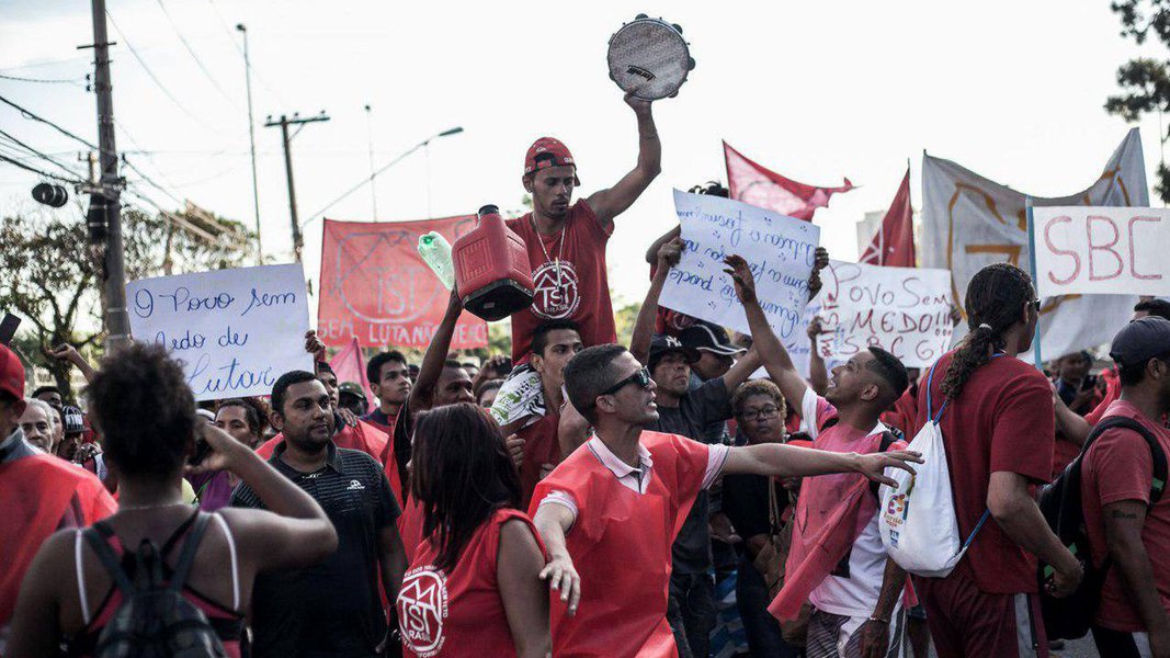Cerca de 300 integrantes do Movimento dos Trabalhadores Sem Teto (MTST) protestam em frente a uma concessionaria da Mercedez Benz onde Michel Temer vai participar de uma cerimônia de entrega de ambulâncias no bairro do Limão, em São Paulo; manifestantes vieram da ocupação Povo Sem Medo em São Bernardo, no ABC paulista; lá, cerca de 7.000 pessoas ocupam um terreno que pertence a uma construtora. O empreendimento é ladeado por um condomínio habitacional de classe média e uma vila (Foto: Aquiles Lins) Cerca de 300 integrantes do Movimento dos Trabalhadores Sem Teto (MTST) protestam em frente a uma concessionaria da Mercedez Benz onde Michel Temer vai participar de uma cerimônia de entrega de ambulâncias no bairro do Limão, em São Paulo; manifestantes vieram da ocupação Povo Sem Medo em São Bernardo, no ABC paulista; lá, cerca de 7.000 pessoas ocupam um terreno que pertence a uma construtora. O empreendimento é ladeado por um condomínio habitacional de classe média e uma vila
