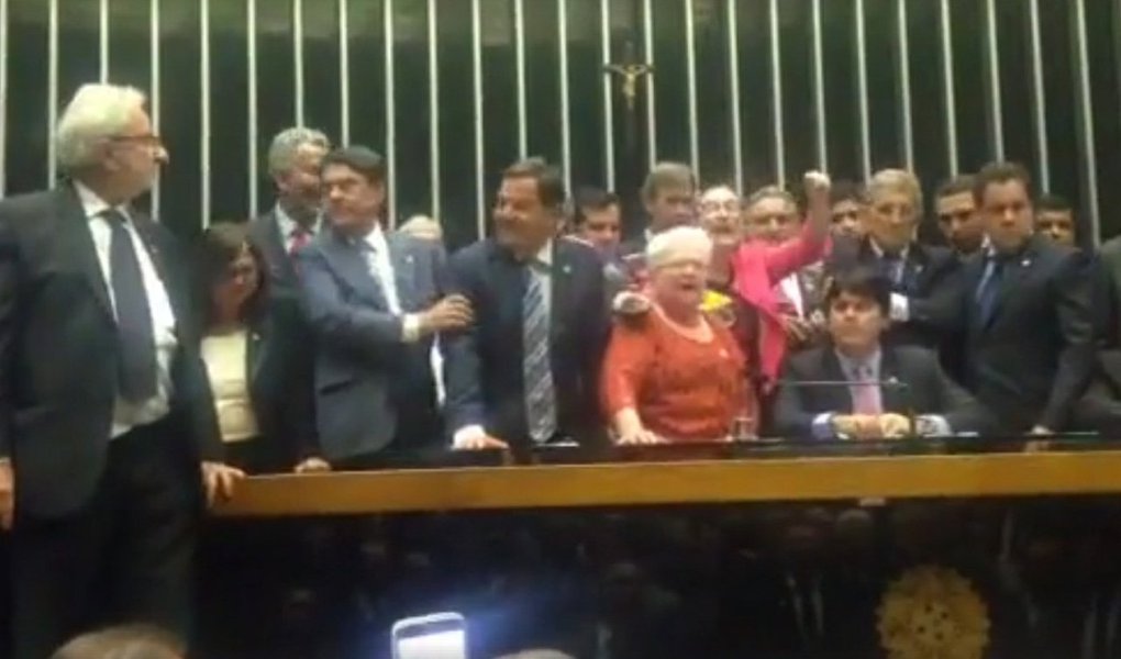 Deputados de oposição ocupam a Mesa Diretora erguendo uma faixa com os dizeres "Fora Temer" e pedem, em coro, a saída de Michel Temer e eleições diretas; oposição cobrou do deputado Carlos Manato (SD-ES), que presidia os trabalhos há pouco, o encerramento da segunda sessão extraordinária desta quarta-feira (24) por conta do tumulto que tomou conta da Esplanada dos Ministérios, onde há enfretamento entre manifestantes do movimento #ocupabrasília e policiais militares do Distrito Federal; deputado Orlando Silva (PCdoB-SP) disse que o ato foi "brutalmente atacada por forças policiais"; "Vários parlamentares que estavam no carro de som principal foram atingidos. Uma bomba foi jogada sobre o carro para intimidar lideranças sindicais", disse Silva, cobrando de Manato o encerramento dos trabalhos (Foto: Aquiles Lins) Deputados de oposição ocupam a Mesa Diretora erguendo uma faixa com os dizeres "Fora Temer" e pedem, em coro, a saída de Michel Temer e eleições diretas; oposição cobrou do deputado Carlos Manato (SD-ES), que presidia os trabalhos há pouco, o encerramento da segunda sessão extraordinária desta quarta-feira (24) por conta do tumulto que tomou conta da Esplanada dos Ministérios, onde há enfretamento entre manifestantes do movimento #ocupabrasília e policiais militares do Distrito Federal; deputado Orlando Silva (PCdoB-SP) disse que o ato foi "brutalmente atacada por forças policiais"; "Vários parlamentares que estavam no carro de som principal foram atingidos. Uma bomba foi jogada sobre o carro para intimidar lideranças sindicais", disse Silva, cobrando de Manato o encerramento dos trabalhos