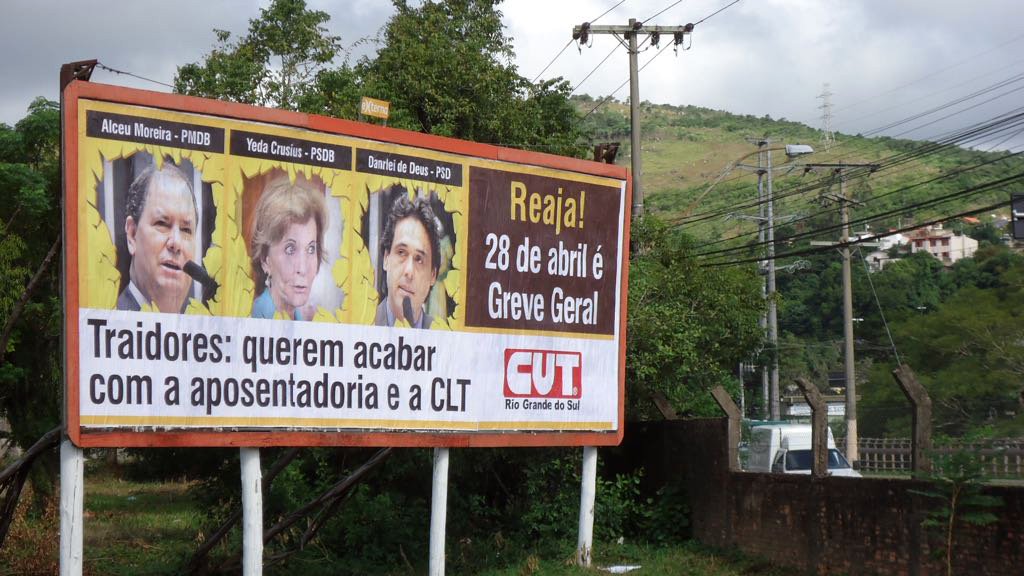 Dezenas de outdoors estão espalhados pela capital e cidades do interior do Rio Grande do Sul com fotos de deputados federais gaúchos que apoiam as reforma Trabalhista e Previdenciária do governo Michel Temer; “Traidores: querem acabar com a aposentadoria e a CLT”, é a principal chamada, ao lado da convocação “Reaja: 28 de abril é greve geral”; os outdoors foram colocados à beira de ruas, avenidas e estradas das principais bases eleitorais dos parlamentares (Foto: Voney Malta) Dezenas de outdoors estão espalhados pela capital e cidades do interior do Rio Grande do Sul com fotos de deputados federais gaúchos que apoiam as reforma Trabalhista e Previdenciária do governo Michel Temer; “Traidores: querem acabar com a aposentadoria e a CLT”, é a principal chamada, ao lado da convocação “Reaja: 28 de abril é greve geral”; os outdoors foram colocados à beira de ruas, avenidas e estradas das principais bases eleitorais dos parlamentares