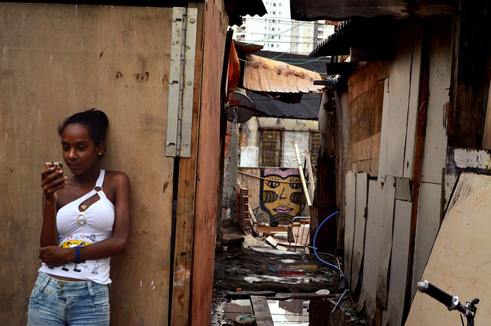 Menina ao celular na favela (Foto: Ângelo Cavalcante) Menina ao celular na favela