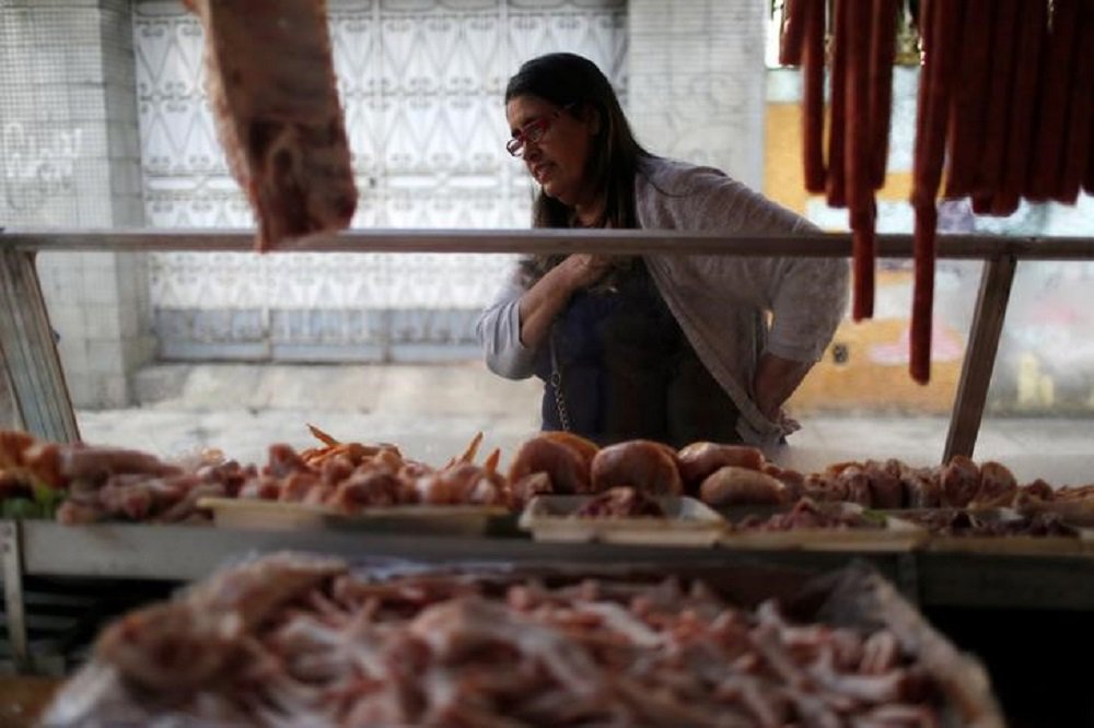 Mulher observa banca com carnes em feira do Rio de Janeiro. 06/05/2016 REUTERS/Pilar Olivares (Foto: Gisele Federicce) Mulher observa banca com carnes em feira do Rio de Janeiro. 06/05/2016 REUTERS/Pilar Olivares