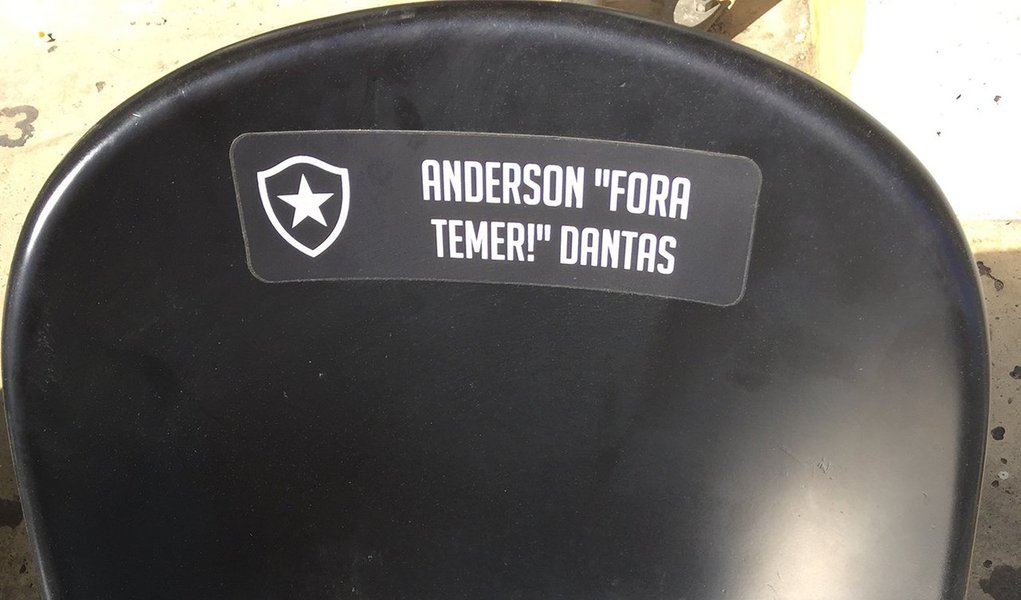 Definitivamente, o futebol não é mais o “ópio do povo”; prova disso foi dada no Estádio Nilton Santos, no Rio, administrado pelo Botafogo; um torcedor do glorioso aderiu ao plano de customização do Niltão, que dá direito a colocar o nome na cadeira por R$ 50,00; de maneira inusitada o torcedor mandou personalizar com os seguintes dizeres: “Anderson ‘Fora, Temer’ Dantas”; ou seja, o amor ao clube serviu para Anderson demonstrar a sua insatisfação com o rumo que tem sido dado ao país pelo ‘mordomo de filme de terror de quinta categoria’ (Foto: Voney Malta) Definitivamente, o futebol não é mais o “ópio do povo”; prova disso foi dada no Estádio Nilton Santos, no Rio, administrado pelo Botafogo; um torcedor do glorioso aderiu ao plano de customização do Niltão, que dá direito a colocar o nome na cadeira por R$ 50,00; de maneira inusitada o torcedor mandou personalizar com os seguintes dizeres: “Anderson ‘Fora, Temer’ Dantas”; ou seja, o amor ao clube serviu para Anderson demonstrar a sua insatisfação com o rumo que tem sido dado ao país pelo ‘mordomo de filme de terror de quinta categoria’