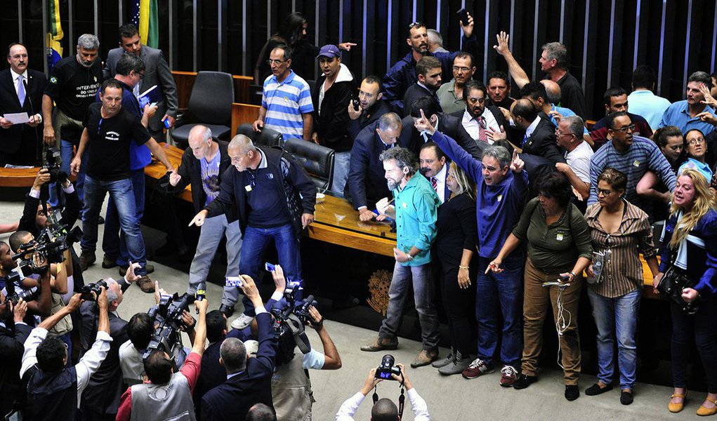"Uns 50 gatos pingados vestindo camisetas pretas pedindo intervenção militar invadiram agora há pouco o plenário da Câmara dos Deputados. Expulsaram o deputado Waldir Maranhão que estava presidindo a sessão e agora ocupam a mesa diretora. A polícia legislativa tenta negociar a retirada pacífica, mas tem obtido êxito relativo. A maioria dos invasores permanece no local da mesa diretora gritando palavras de ordem contra “comunistas”, “corruptos” e exigindo a presença do comandante geral das Forças Armadas. Notórios provocadores, protagonizam cenas que só se viu na ditadura militar de 64"; confira o relato do colunista Alex Solnik (Foto: Alex Solnik) "Uns 50 gatos pingados vestindo camisetas pretas pedindo intervenção militar invadiram agora há pouco o plenário da Câmara dos Deputados. Expulsaram o deputado Waldir Maranhão que estava presidindo a sessão e agora ocupam a mesa diretora. A polícia legislativa tenta negociar a retirada pacífica, mas tem obtido êxito relativo. A maioria dos invasores permanece no local da mesa diretora gritando palavras de ordem contra “comunistas”, “corruptos” e exigindo a presença do comandante geral das Forças Armadas. Notórios provocadores, protagonizam cenas que só se viu na ditadura militar de 64"; confira o relato do colunista Alex Solnik