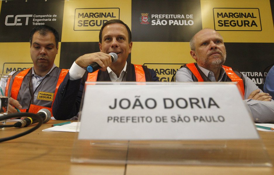Durante coletiva de imprensa sobre o programa Marginal Segura, uma mulher entregou ao prefeito de São Paulo, João Doria (PSDB), um buquê de flores em homenagem aos mortos que serão contabilizados agora com o aumento do limite de velocidade das marginais; um rapaz levantou um cartaz com os dizeres: "em memória aos mortos no trânsito"; nesta quarta, dia de mudança nos limites, foram registrados cinco acidentes (Foto: Gisele Federicce) Durante coletiva de imprensa sobre o programa Marginal Segura, uma mulher entregou ao prefeito de São Paulo, João Doria (PSDB), um buquê de flores em homenagem aos mortos que serão contabilizados agora com o aumento do limite de velocidade das marginais; um rapaz levantou um cartaz com os dizeres: "em memória aos mortos no trânsito"; nesta quarta, dia de mudança nos limites, foram registrados cinco acidentes