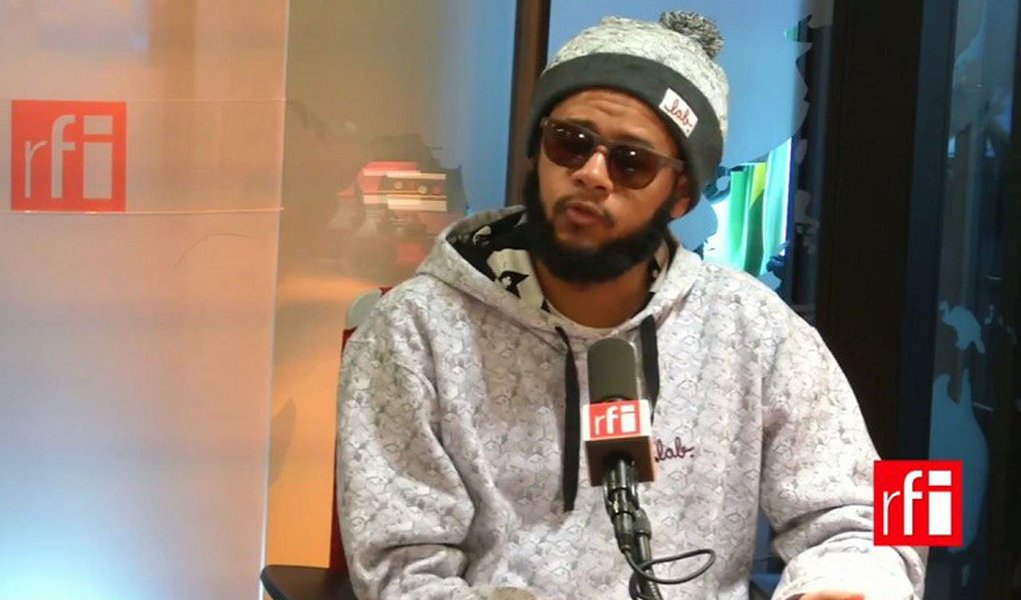 Em turnê por países da Europa, o rapper Emicida criticou o golpe parlamentar em curso no Brasil; "A questão do impedimento da presidente Dilma Rousseff é algo que me entristece muito, porque o princípio da democracia é o voto. Se existe uma possibilidade de um grupo de pessoas fazer com que 54 milhões de votos percam força, precisamos nos preocupar muito com a solidez da democracia no Brasil", disse ele em entrevista à rádio francesa RFI; assista (Foto: Aquiles Lins) Em turnê por países da Europa, o rapper Emicida criticou o golpe parlamentar em curso no Brasil; "A questão do impedimento da presidente Dilma Rousseff é algo que me entristece muito, porque o princípio da democracia é o voto. Se existe uma possibilidade de um grupo de pessoas fazer com que 54 milhões de votos percam força, precisamos nos preocupar muito com a solidez da democracia no Brasil", disse ele em entrevista à rádio francesa RFI; assista