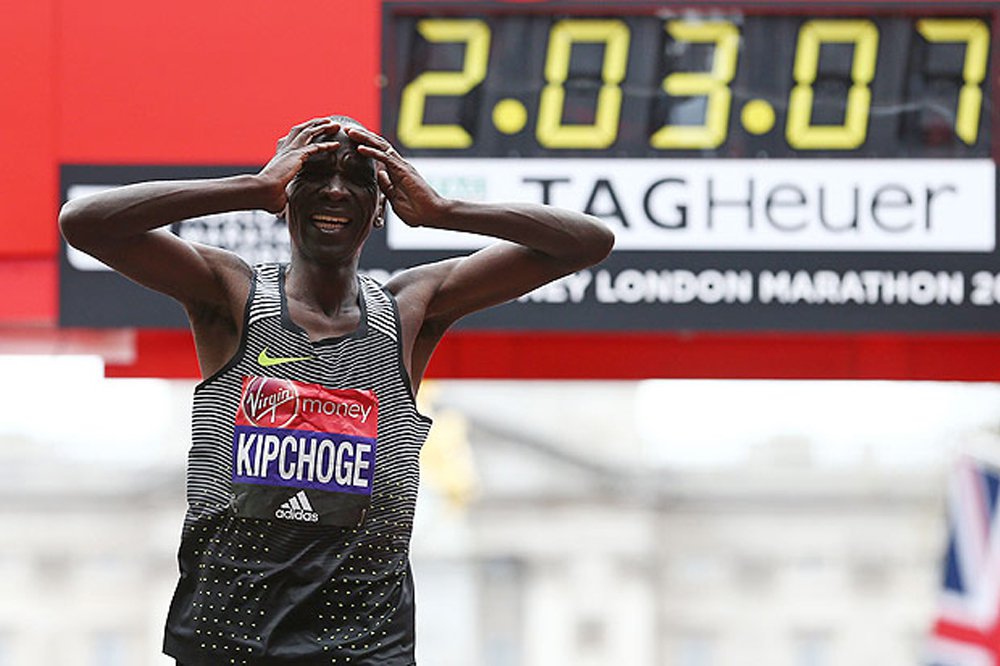 O queniano Eliud Kipchoge atingiu neste domingo a segunda melhor marca da história de uma maratona, defendendo com êxito o título conquistado ano passado em Londres, enquanto sua compatriota Jemima Sumgong venceu a categoria feminina; Kipchoge, que marcou um tempo de duas horas, três minutos e cinco segundos, parecia um pouco decepcionado por acabar a oito segundos do recorde de 2:02:57 de Dennis Kimetto (Foto: Romulo Faro) O queniano Eliud Kipchoge atingiu neste domingo a segunda melhor marca da história de uma maratona, defendendo com êxito o título conquistado ano passado em Londres, enquanto sua compatriota Jemima Sumgong venceu a categoria feminina; Kipchoge, que marcou um tempo de duas horas, três minutos e cinco segundos, parecia um pouco decepcionado por acabar a oito segundos do recorde de 2:02:57 de Dennis Kimetto