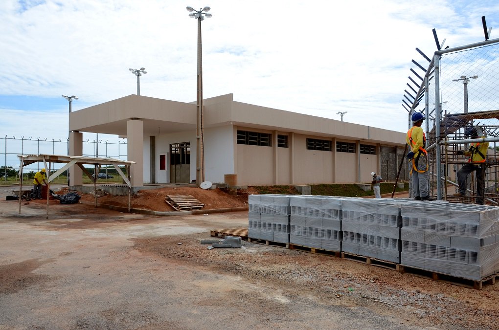 A Agetop executa obras de construção de quatro presídios estaduais, nas cidades de Anápolis, Formosa, Águas Lindas de Goiás e Novo Gama; como cada um possui 300 vagas, serão disponibilizadas 1,2 mil celas para o Sistema Prisional, com objetivo de melhorar e ampliar a capacidade do sistema carcerário no Estado; presídio de Anápolis (na foto) encontra-se com 85% das obras concluídas; são executados no local pintura dos blocos, plantio de grama, implantação do alambrado e instalações elétricas (Foto: José Barbacena) A Agetop executa obras de construção de quatro presídios estaduais, nas cidades de Anápolis, Formosa, Águas Lindas de Goiás e Novo Gama; como cada um possui 300 vagas, serão disponibilizadas 1,2 mil celas para o Sistema Prisional, com objetivo de melhorar e ampliar a capacidade do sistema carcerário no Estado; presídio de Anápolis (na foto) encontra-se com 85% das obras concluídas; são executados no local pintura dos blocos, plantio de grama, implantação do alambrado e instalações elétricas