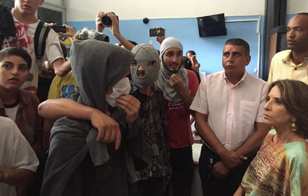 Secretária estadual de Educação, Raquel Teixeira, se esforçou para dialogar com os manifestantes que ocupam escolas da Capital em protesto ao projeto de instalação das Organizações Sociais; grupo esteve na sede da Seduce ontem e exigiu a presença da secretária, que deixou seu gabinete e se mostrou aberta ao diálogo; porém, líderes mascarados insistiram numa postura agressiva e não descobriram o rosto mesmo após pedido de Raquel Teixeira; gritos em megafone e palavras de ordem impediam que a secretária esclarecesse dúvidas sobre as OS no ensino público (Foto: José Barbacena) Secretária estadual de Educação, Raquel Teixeira, se esforçou para dialogar com os manifestantes que ocupam escolas da Capital em protesto ao projeto de instalação das Organizações Sociais; grupo esteve na sede da Seduce ontem e exigiu a presença da secretária, que deixou seu gabinete e se mostrou aberta ao diálogo; porém, líderes mascarados insistiram numa postura agressiva e não descobriram o rosto mesmo após pedido de Raquel Teixeira; gritos em megafone e palavras de ordem impediam que a secretária esclarecesse dúvidas sobre as OS no ensino público