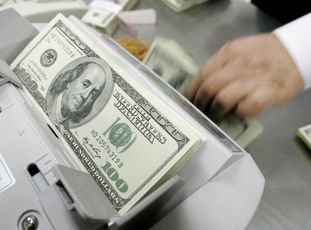 Um funcionário de um banco conta notas de cem dólares na sede do banco em Seul. O dólar chegou a recuar 2 por cento nesta quinta-feira, à casa dos 2,26 reais, após pesquisa mostrar queda na aprovação do governo da presidente Dilma Rousseff, num momento em (Foto: Paulo Emílio) Um funcionário de um banco conta notas de cem dólares na sede do banco em Seul. O dólar chegou a recuar 2 por cento nesta quinta-feira, à casa dos 2,26 reais, após pesquisa mostrar queda na aprovação do governo da presidente Dilma Rousseff, num momento em