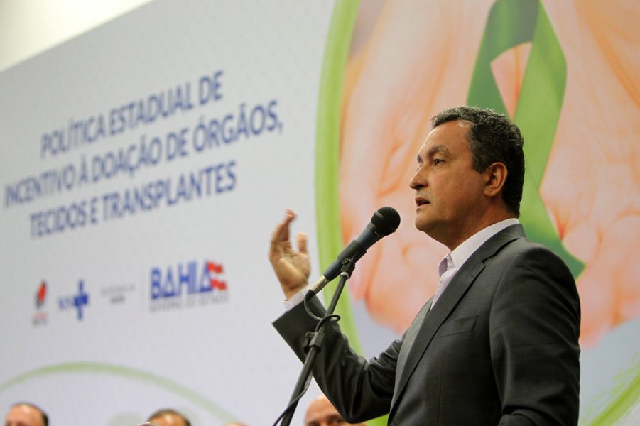 O governador Rui Costa lançou nesta terça-feira a 'Política Estadual de Incentivo à Doação de Órgãos, Tecidos e Transplantes', cujo objetivo é promover ações que incentivem a população e capacitem os profissionais de saúde para multiplicar o número de doação de órgãos na Bahia; para tanto, mais de R$ 10 milhões serão investidos por ano; "Eu acredito que com determinação e trabalho todos os desafios podem ser superados. Esse ano, em termos de recursos, está muito difícil para a Bahia, mas aqui queremos fazer mais e melhor, gastando menos, e por isso estamos apostando nessa iniciativa. Primeiro porque daremos qualidade de vida a milhares de pessoas, mas como se isso tudo não bastasse, vamos reduzir o custo de tratamentos, com o transplante", disse Rui (Foto: Romulo Faro) O governador Rui Costa lançou nesta terça-feira a 'Política Estadual de Incentivo à Doação de Órgãos, Tecidos e Transplantes', cujo objetivo é promover ações que incentivem a população e capacitem os profissionais de saúde para multiplicar o número de doação de órgãos na Bahia; para tanto, mais de R$ 10 milhões serão investidos por ano; "Eu acredito que com determinação e trabalho todos os desafios podem ser superados. Esse ano, em termos de recursos, está muito difícil para a Bahia, mas aqui queremos fazer mais e melhor, gastando menos, e por isso estamos apostando nessa iniciativa. Primeiro porque daremos qualidade de vida a milhares de pessoas, mas como se isso tudo não bastasse, vamos reduzir o custo de tratamentos, com o transplante", disse Rui