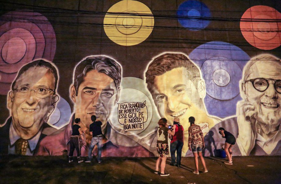 O Levante Popular da Juventude realizou uma intervenção no mural criado para comemorar os 50 anos da emissora, colocando balões de conversa nas imagens de Roberto Marinho, William Bonner e Luciano Huck com as frases “Em 1964 foi a minha vez, agora é com vocês” e “Fica tranquilo Dr. Roberto! Esse golpe é nosso! Boa noite! “ (Foto: Leonardo Attuch) O Levante Popular da Juventude realizou uma intervenção no mural criado para comemorar os 50 anos da emissora, colocando balões de conversa nas imagens de Roberto Marinho, William Bonner e Luciano Huck com as frases “Em 1964 foi a minha vez, agora é com vocês” e “Fica tranquilo Dr. Roberto! Esse golpe é nosso! Boa noite! “