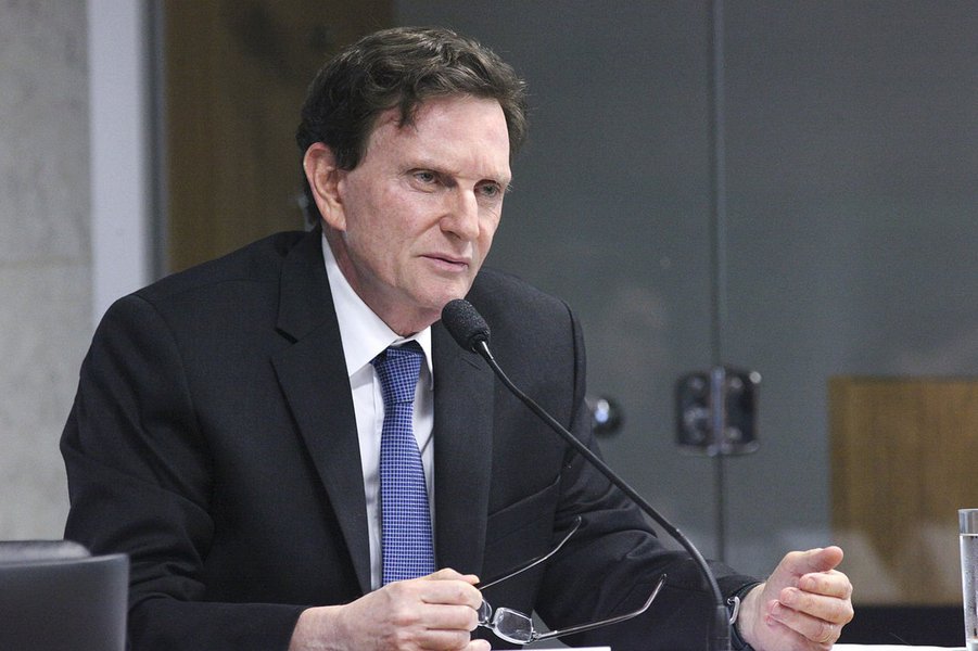 Logo após tomar posse neste domingo, o prefeito do Rio, Marcelo Crivella (PRB), reiterou seu compromisso com a política de austeridade econômica, com corte de gastos, e apresentou a proposta de reforçar o caixa da prefeitura com a cobrança de uma taxa de R$ 4 a R$ 5 dos turistas que vierem à 'cidade maravilhosa'; segundo Crivella, a taxa não vai onerar os pacotes turísticos, é uma prática já adotada em vários países, mas será fundamental para reforçar o caixa do município; mas a medida não foi muito bem recebida para especialistas do setor; para o presidente nacional da Associação Brasileira de Agências de Viagem, Edmar Bull, o anúncio "ocorre em um momento inadequado" (Foto: Romulo Faro) Logo após tomar posse neste domingo, o prefeito do Rio, Marcelo Crivella (PRB), reiterou seu compromisso com a política de austeridade econômica, com corte de gastos, e apresentou a proposta de reforçar o caixa da prefeitura com a cobrança de uma taxa de R$ 4 a R$ 5 dos turistas que vierem à 'cidade maravilhosa'; segundo Crivella, a taxa não vai onerar os pacotes turísticos, é uma prática já adotada em vários países, mas será fundamental para reforçar o caixa do município; mas a medida não foi muito bem recebida para especialistas do setor; para o presidente nacional da Associação Brasileira de Agências de Viagem, Edmar Bull, o anúncio "ocorre em um momento inadequado"