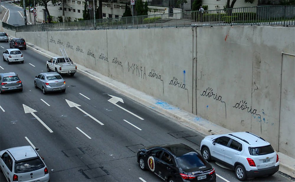 Após o prefeito de São Paulo, João Doria (PSDB), mandar cobrir de tinta cinza os muros da Avenida 23 de Maio, que estavam cheios de grafites, seu nome foi pichado repetidas vezes; funcionários da Prefeitura já pintaram novamente o muro, apagando as pichações (Foto: Ana Pupulin) Após o prefeito de São Paulo, João Doria (PSDB), mandar cobrir de tinta cinza os muros da Avenida 23 de Maio, que estavam cheios de grafites, seu nome foi pichado repetidas vezes; funcionários da Prefeitura já pintaram novamente o muro, apagando as pichações
