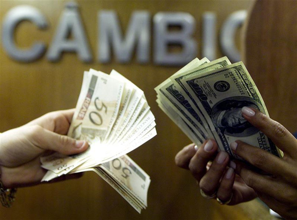 Brasileiro troca reais por dólares em corretora de câmbio no centro do Rio de Janeiro. O dólar fechou em baixa frente ao real nesta terça-feira, interrompendo sequência de duas altas, num pregão marcado por forte volatilidade e novamente com o Banco Centr (Foto: Paulo Emílio) Brasileiro troca reais por dólares em corretora de câmbio no centro do Rio de Janeiro. O dólar fechou em baixa frente ao real nesta terça-feira, interrompendo sequência de duas altas, num pregão marcado por forte volatilidade e novamente com o Banco Centr