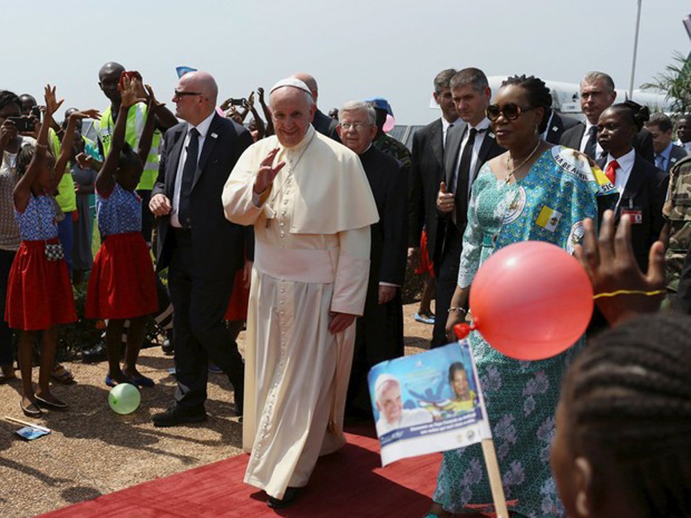 Protegido pelo esquema de segurança mais reforçado em suas viagens, o papa Francisco pediu neste domingo pela reconciliação da República Centro-Africana, um país afetado há anos pela violência entre muçulmanos e cristãos; "Trabalhem, rezem, façam tudo pela paz. Mas, lembrem-se, a paz sem amor, amizade e tolerância, não é nada", disse o pontífice; no momento em que seu avião pousou na capital Bangui, helicópteros de ataque patrulhavam os céus e forças de paz das Nações Unidas e do Exército francês esperavam do lado de fora do aeroporto (Foto: Romulo Faro) Protegido pelo esquema de segurança mais reforçado em suas viagens, o papa Francisco pediu neste domingo pela reconciliação da República Centro-Africana, um país afetado há anos pela violência entre muçulmanos e cristãos; "Trabalhem, rezem, façam tudo pela paz. Mas, lembrem-se, a paz sem amor, amizade e tolerância, não é nada", disse o pontífice; no momento em que seu avião pousou na capital Bangui, helicópteros de ataque patrulhavam os céus e forças de paz das Nações Unidas e do Exército francês esperavam do lado de fora do aeroporto
