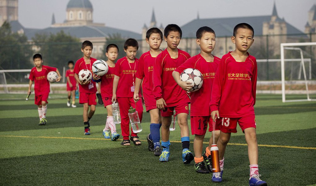 Wang Shijie, 11 anos, é uma estrela em ascensão entre os cerca de 3 mil alunos da enorme academia de futebol do Guangzhou Evergrande, no sul da China; ele quer se juntar à equipe nacional e ajudar o país a alcançar o sonho do presidente chinês Xi Jinping de ganhar a Copa do Mundo; com escolas como essa espalhadas por todo o país, a China prepara um exército de jovens jogadores que espera que possam ajudar a nação a sair de sua baixa posição entre os líderes do futebol mundial; a China atualmente ocupa o 84º lugar de 209 países, acima do Qatar e abaixo de equipes como Jordânia, Montenegro e Gabão (Foto: Leonardo Lucena) Wang Shijie, 11 anos, é uma estrela em ascensão entre os cerca de 3 mil alunos da enorme academia de futebol do Guangzhou Evergrande, no sul da China; ele quer se juntar à equipe nacional e ajudar o país a alcançar o sonho do presidente chinês Xi Jinping de ganhar a Copa do Mundo; com escolas como essa espalhadas por todo o país, a China prepara um exército de jovens jogadores que espera que possam ajudar a nação a sair de sua baixa posição entre os líderes do futebol mundial; a China atualmente ocupa o 84º lugar de 209 países, acima do Qatar e abaixo de equipes como Jordânia, Montenegro e Gabão