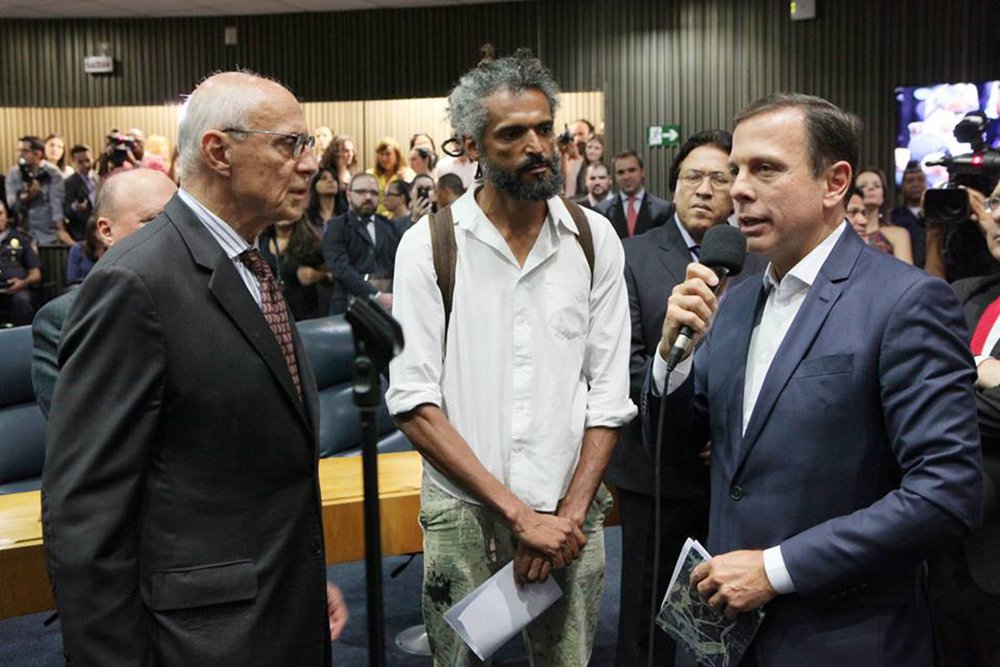 Na primeira sessão da Câmara Municipal de São Paulo, o vereador Eduardo Suplicy (PT) apresentou ao prefeito João Doria (PSDB) o Mauro Neri da Silva – detido na semana passada ao tentar restaurar um de seus trabalhos apagados por Doria; "Vou te entregar este livro que conta um pouco da história do Mauro e sugiro que ele possa ser escutado em uma reunião com Vossa Excelência", disse Suplicy; Mauro não teve microfone aberto, mas falou com a imprensa (Foto: Aquiles Lins) Na primeira sessão da Câmara Municipal de São Paulo, o vereador Eduardo Suplicy (PT) apresentou ao prefeito João Doria (PSDB) o Mauro Neri da Silva – detido na semana passada ao tentar restaurar um de seus trabalhos apagados por Doria; "Vou te entregar este livro que conta um pouco da história do Mauro e sugiro que ele possa ser escutado em uma reunião com Vossa Excelência", disse Suplicy; Mauro não teve microfone aberto, mas falou com a imprensa
