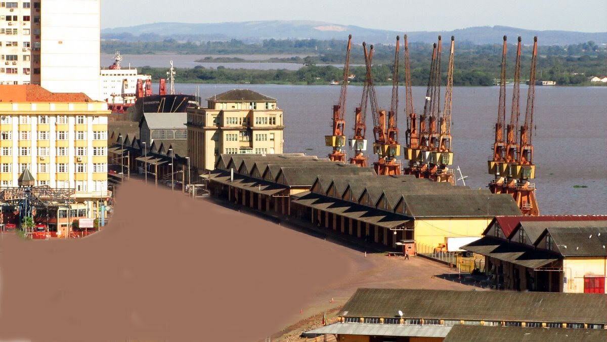 Não foram apenas prejuízos e sustos que a enchente dos últimos dias causou aos gaúchos; em Porto Alegre a histórica marca atingida pelo Rio Guaíba levantou a polêmica sobre a permanência ou não do muro do Cais Mauá; ele foi construído após os temores levantados pelo alagamento dos anos 40; estrutura de concreto separa os armazéns da cidade e teve sua permanência questionada por ativistas de um projeto alternativo de revitalização para o Cais, que defendem alternativas como comportas móveis instaladas à beira do rio (Foto: Voney Malta) Não foram apenas prejuízos e sustos que a enchente dos últimos dias causou aos gaúchos; em Porto Alegre a histórica marca atingida pelo Rio Guaíba levantou a polêmica sobre a permanência ou não do muro do Cais Mauá; ele foi construído após os temores levantados pelo alagamento dos anos 40; estrutura de concreto separa os armazéns da cidade e teve sua permanência questionada por ativistas de um projeto alternativo de revitalização para o Cais, que defendem alternativas como comportas móveis instaladas à beira do rio