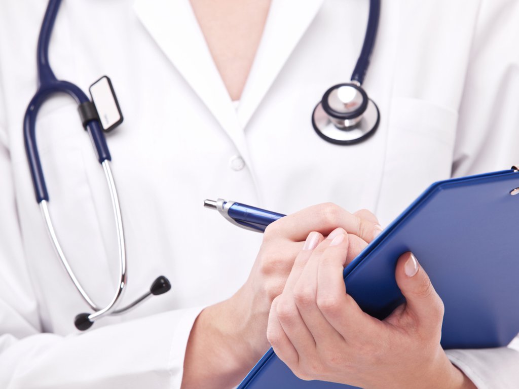 Doctor completing on medical card. Isolated on a white. (Foto: Rodrigo Rocha) Doctor completing on medical card. Isolated on a white.