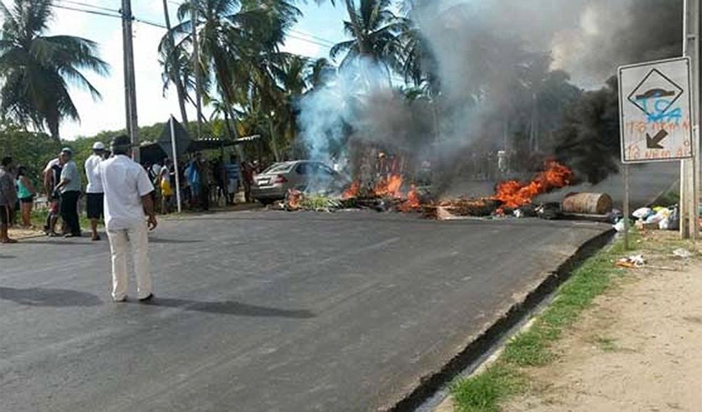 Moradores do bairro de Pescaria, em Maceió, interditaram a rodovia AL-101 Norte em protesto contra uma ação da Polícia Militar; policiais são acusados de terem atirado em um homem que aguardava um ônibus (Foto: Voney Malta) Moradores do bairro de Pescaria, em Maceió, interditaram a rodovia AL-101 Norte em protesto contra uma ação da Polícia Militar; policiais são acusados de terem atirado em um homem que aguardava um ônibus