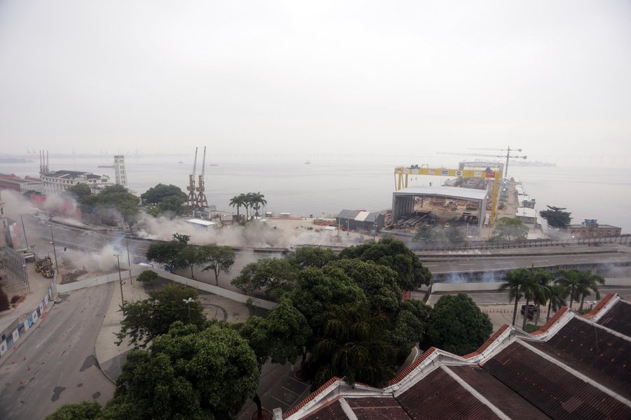Um novo trecho do Elevado da Perimetral, na Zona Portuária do Rio de Janeiro, foi implodido na manhã deste domingo (20). Para efetivar a demolição de 300 metros do viaduto, entre a Marinha e a Polícia Federal, na altura da Praça Mauá, foram empregados 250 quilos de explosivos; os cerca de 4 mil metros cúbicos de concreto foram implodidos em menos de três segundos; a implosão faz parte de um projeto de recuperação da área degradada da Zona Portuária; quando o projeto for concluído, um túnel substituirá a Perimetral e a Rodrigues Alves será transformada em uma via expressa (Foto: Camila Nunes) Um novo trecho do Elevado da Perimetral, na Zona Portuária do Rio de Janeiro, foi implodido na manhã deste domingo (20). Para efetivar a demolição de 300 metros do viaduto, entre a Marinha e a Polícia Federal, na altura da Praça Mauá, foram empregados 250 quilos de explosivos; os cerca de 4 mil metros cúbicos de concreto foram implodidos em menos de três segundos; a implosão faz parte de um projeto de recuperação da área degradada da Zona Portuária; quando o projeto for concluído, um túnel substituirá a Perimetral e a Rodrigues Alves será transformada em uma via expressa