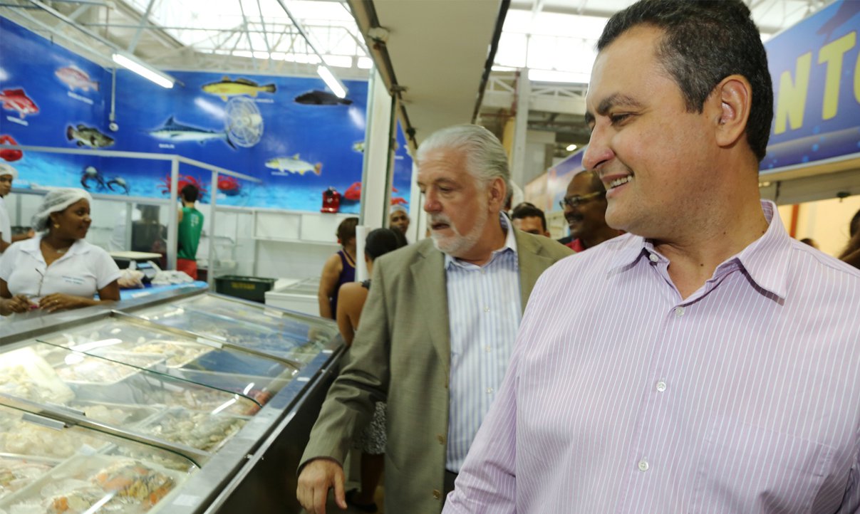 O pré-candidato do PT ao governo do Estado, Rui Costa, participou hoje de inauguração de obra com o governador Jaques Wagner, seu padrinho político, e não desperdiçou vantagem de ter consigo a 'máquina', coisa que seus adversários não têm; "Com ações estruturantes que vão dar mobilidade ao desenvolvimento urbano, passando pela saúde e outras áreas, Wagner marcou seu nome na história da Bahia como o governador que mais investiu em Salvador", disse Rui em discurso completamente fora do contexto do evento, que foi o de reinauguração da antiga Ceasinha, agora chamada de Marcado do Rio Vermelho (Foto: Romulo Faro) O pré-candidato do PT ao governo do Estado, Rui Costa, participou hoje de inauguração de obra com o governador Jaques Wagner, seu padrinho político, e não desperdiçou vantagem de ter consigo a 'máquina', coisa que seus adversários não têm; "Com ações estruturantes que vão dar mobilidade ao desenvolvimento urbano, passando pela saúde e outras áreas, Wagner marcou seu nome na história da Bahia como o governador que mais investiu em Salvador", disse Rui em discurso completamente fora do contexto do evento, que foi o de reinauguração da antiga Ceasinha, agora chamada de Marcado do Rio Vermelho